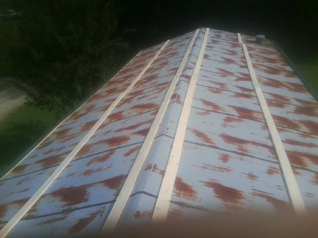 Rusted metal roof panels with new wood purlins before replacement — Storm Damage Roof Repair in Smiley by Roofing Brothers