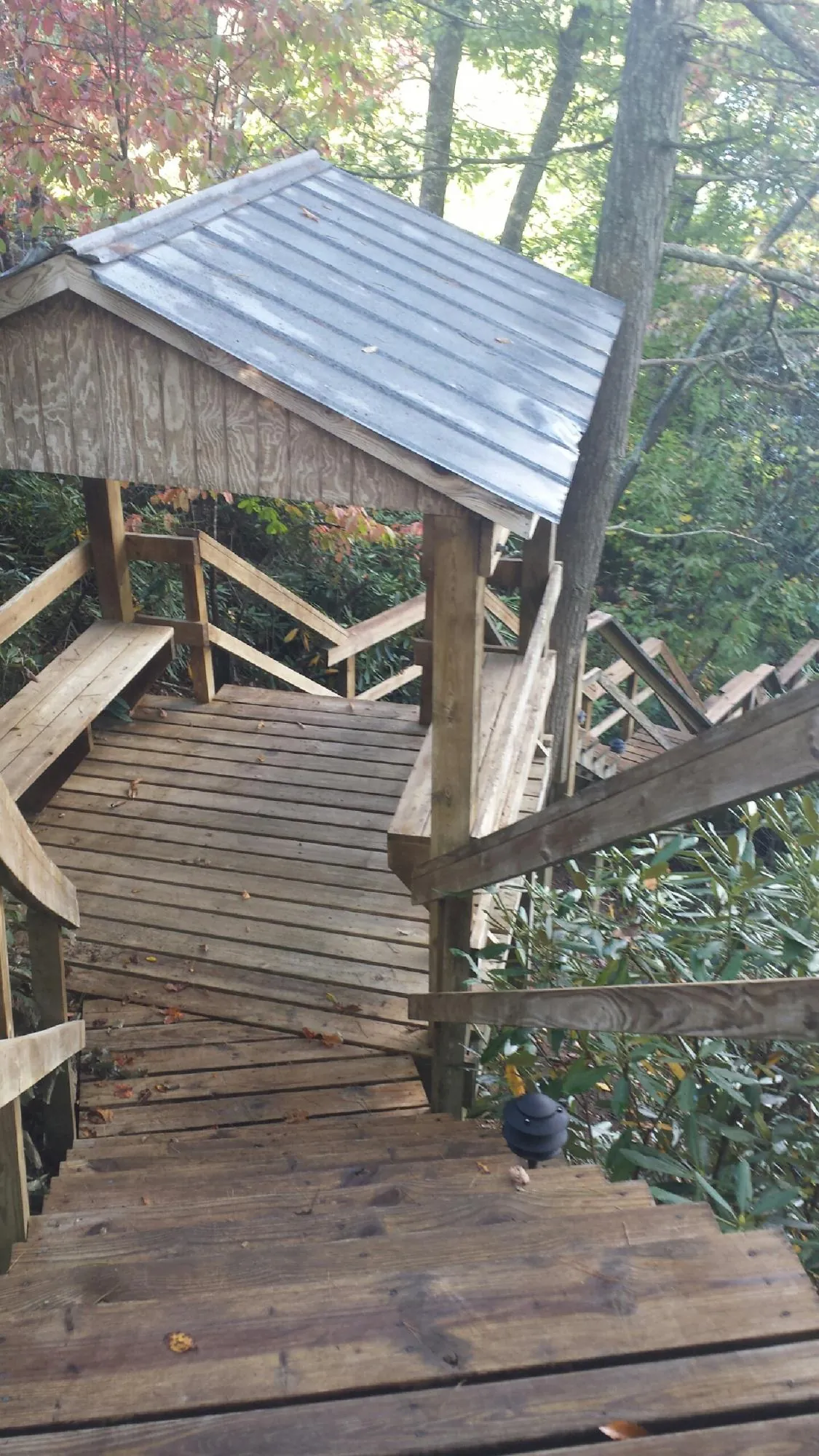 Metal roofed shelter over wooden steps on a wooded walkway — Skylight Repair & Installation work by our crew in Smiley