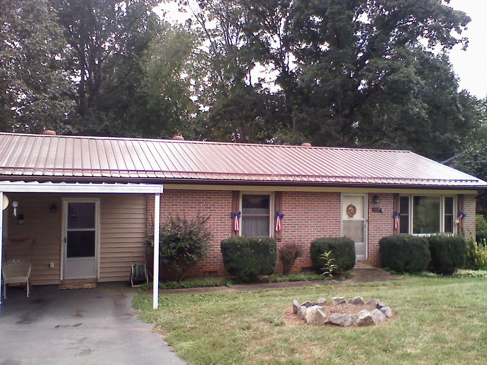 Bronze metal roof and carport on a brick ranch home — Roof Repair work by our crew in Smiley