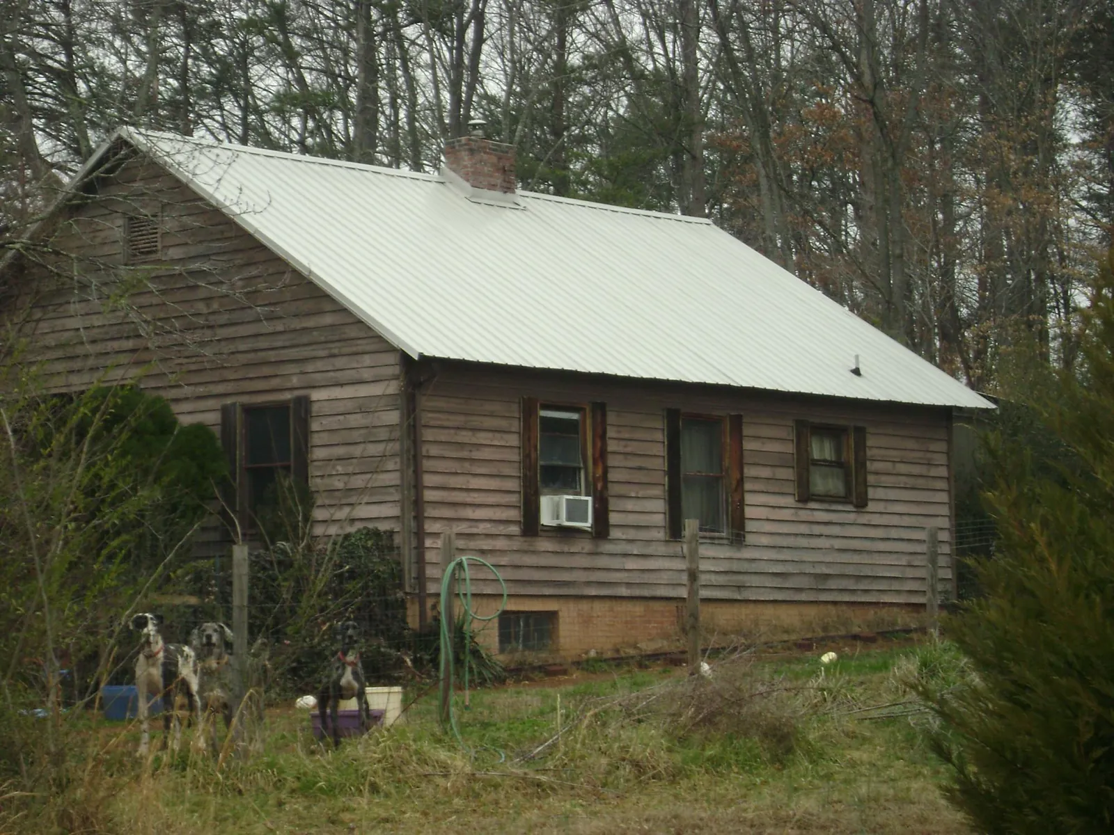 White metal roof on an old wood sided farmhouse, from a Metal Roof Installation job in Smiley